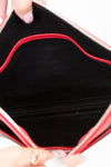 Close-up of a purse's black interior with red stitching held by a hand.