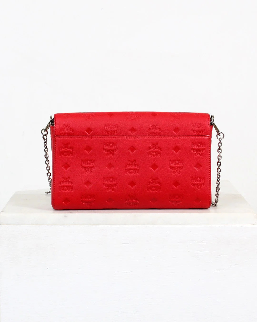 Red handbag with a chain strap on a white background