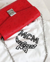 Red handbag with silver chain and MCM logo on a white background