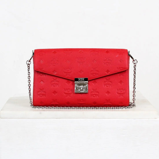 Red handbag with a silver chain on a white background