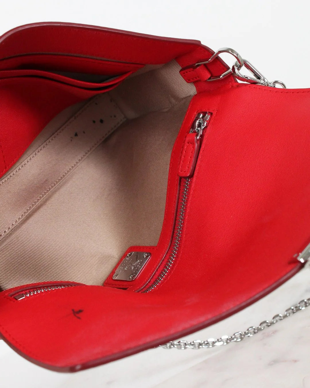 Red handbag with a chain detail on a white background