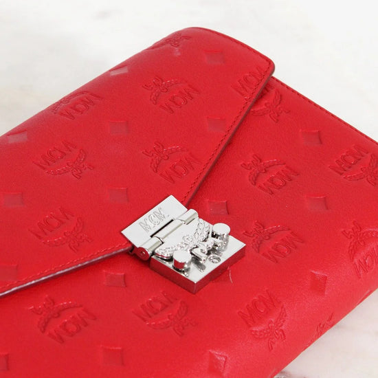 Red embossed wallet with a silver clasp on a white background