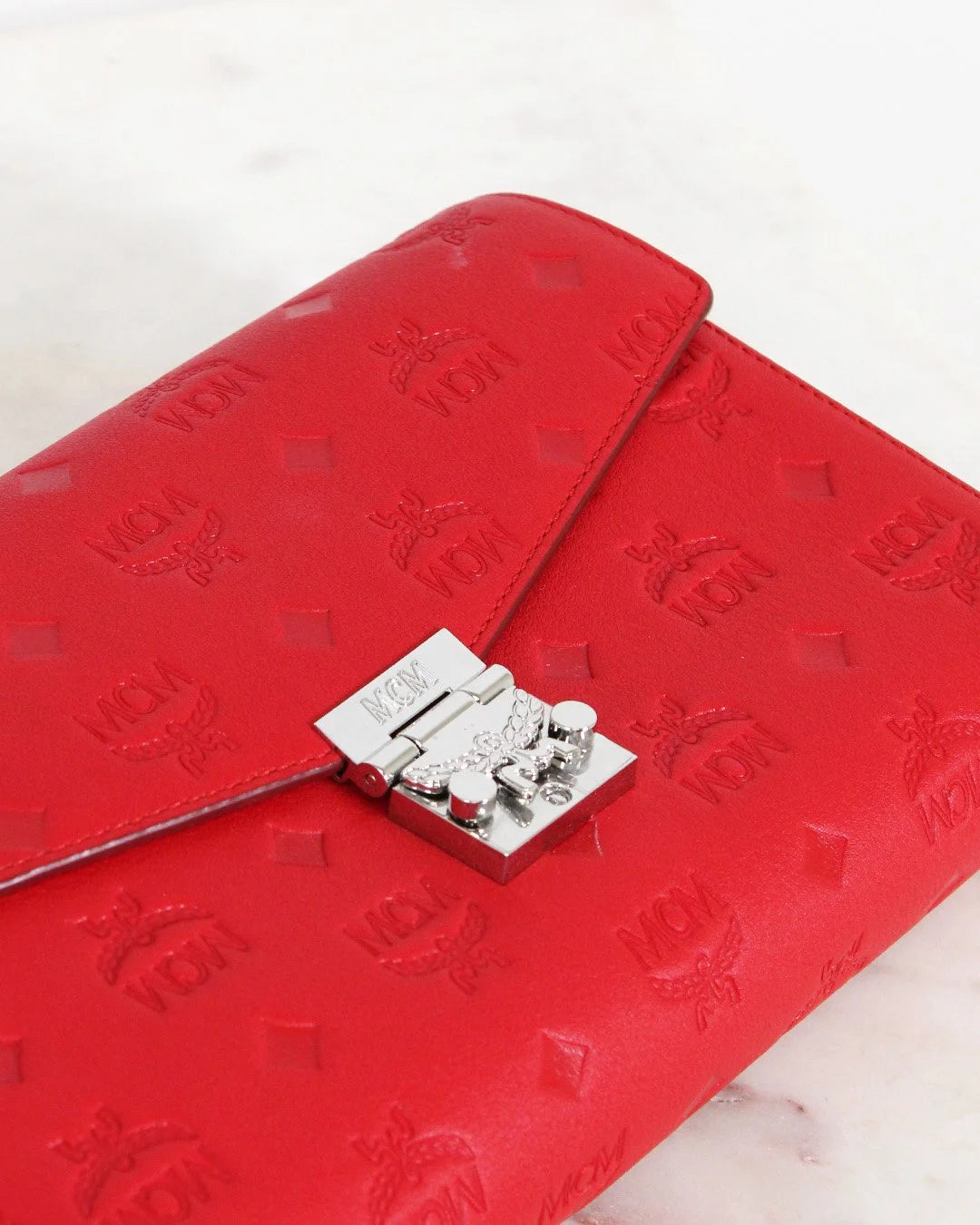 Red embossed wallet with a silver clasp on a white background