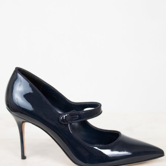 Navy blue patent leather high-heeled shoe with a strap on a white background