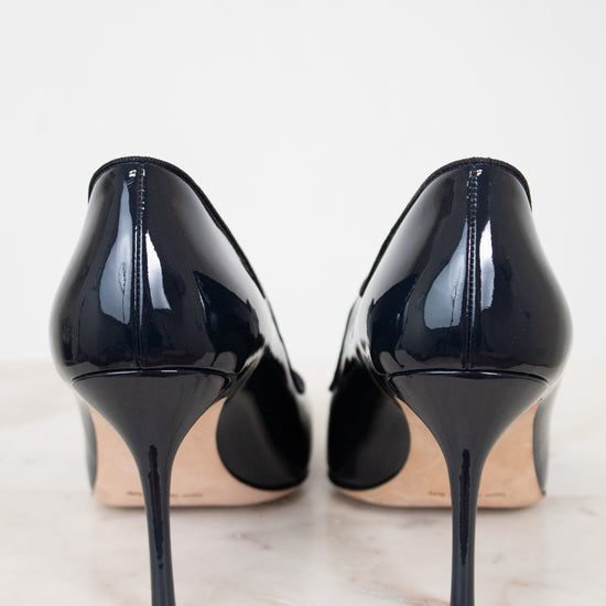 Pair of navy high-heeled shoes on a light background