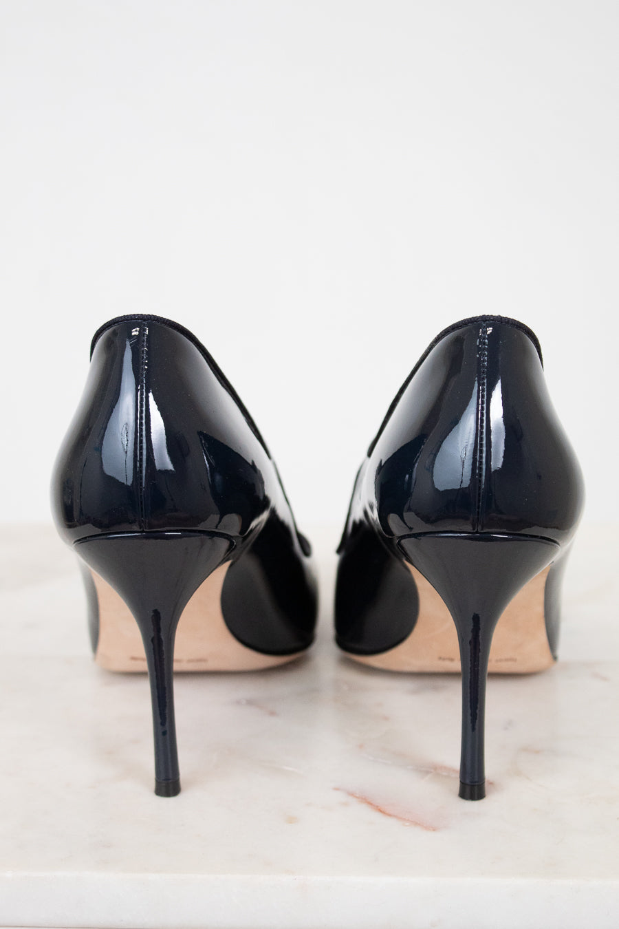 Pair of navy high-heeled shoes on a light background