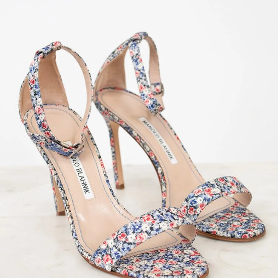 Pair of floral high-heeled sandals on a white background