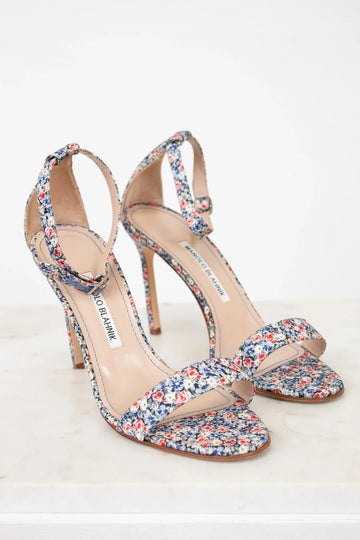 Pair of floral high-heeled sandals on a white background
