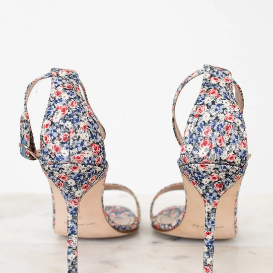 Pair of floral high-heeled shoes on a white background