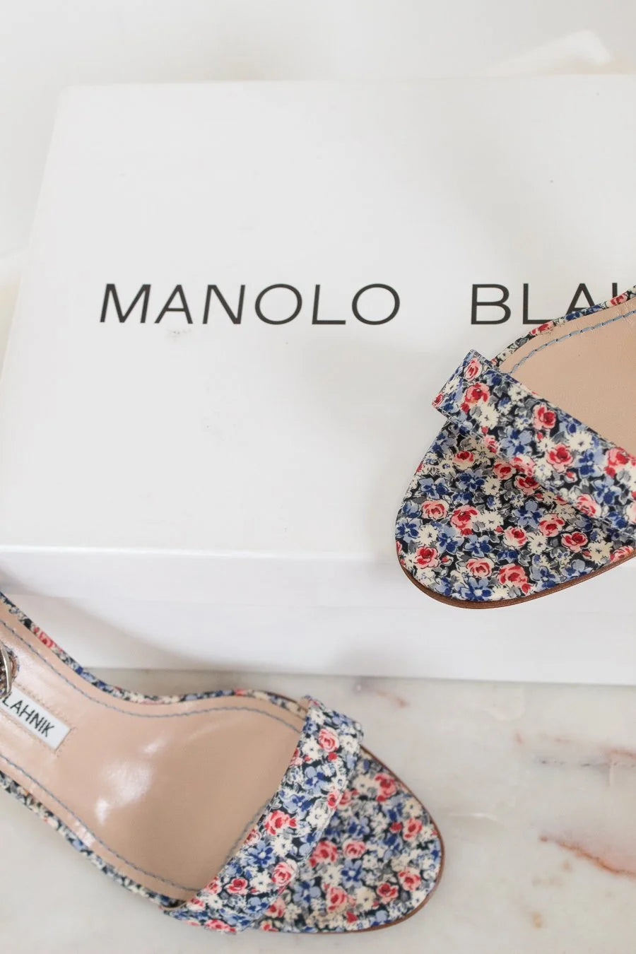Floral shoes on a Manolo Blahnik box with a white background