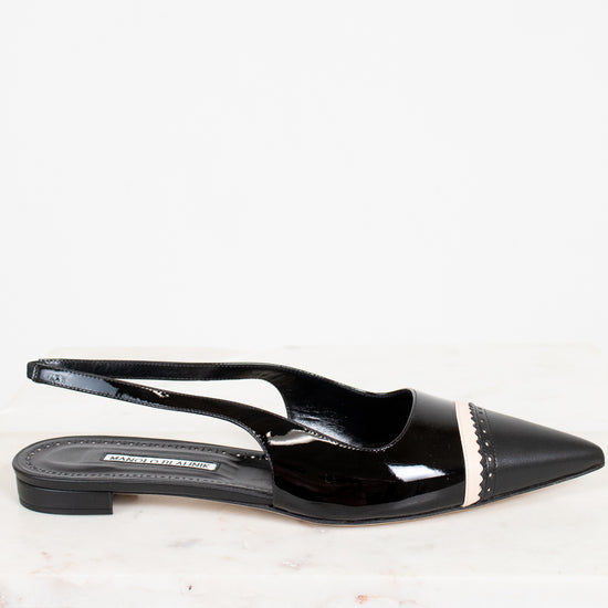 Black patent leather slingback shoes with a pointed toe on a white background