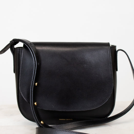 Black leather crossbody bag on a light gray background