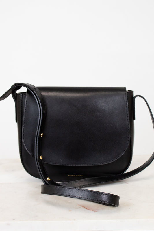 Black leather crossbody bag on a light gray background