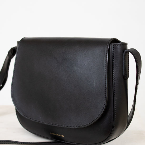 Black leather handbag on a light background