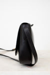 Black leather crossbody bag on a light gray background