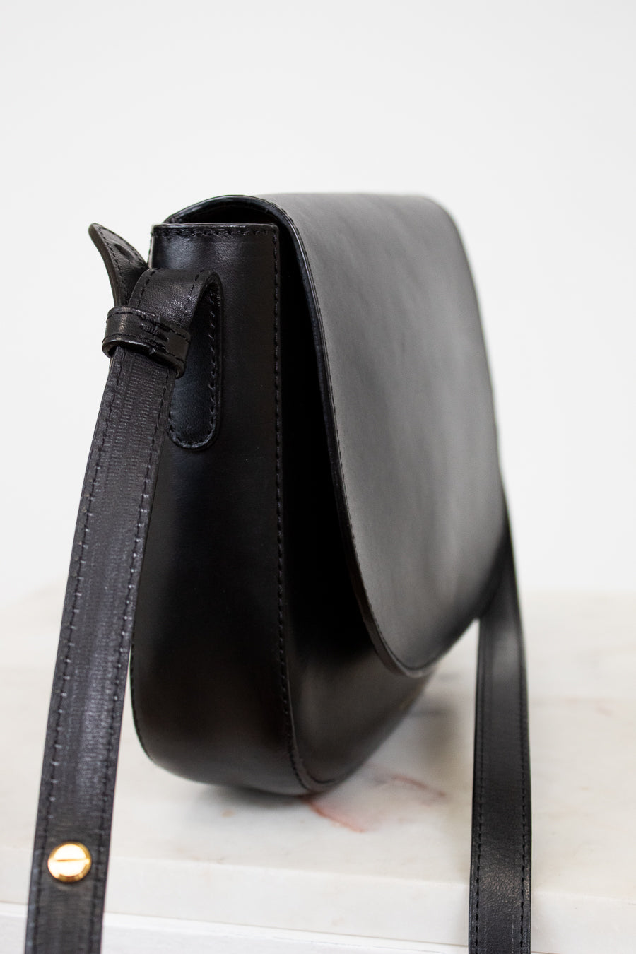 Black leather bag with a strap on a white background