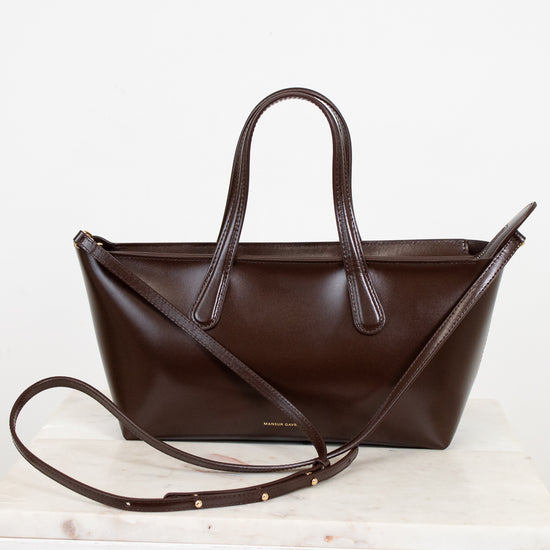 Brown leather handbag with a strap on a white background