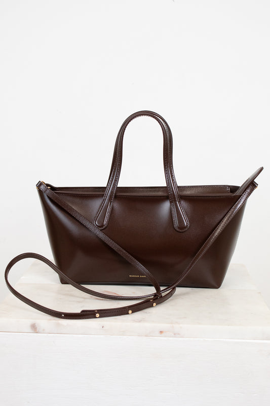 Brown leather handbag with a strap on a white background