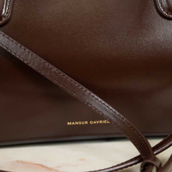 Brown leather handbag with visible brand name on a marble surface