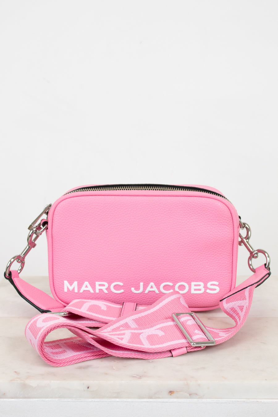 Pink handbag with 'Marc Jacobs' logo on a light background