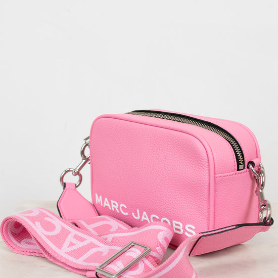 Pink handbag with 'Marc Jacobs' branding on a light background