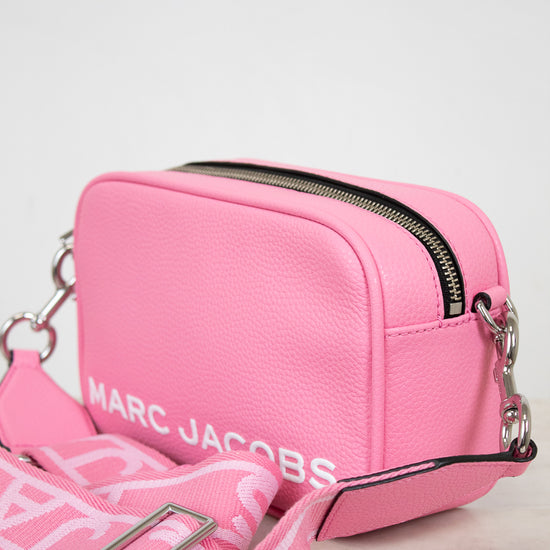 Pink handbag with visible 'Marc Jacobs' branding on a light background