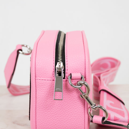 Pink handbag with a silver zipper and matching strap on a light background