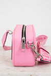 Pink handbag with a silver zipper and matching strap on a light background