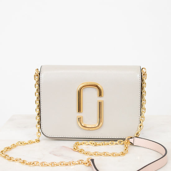 White handbag with gold chain and logo on a white background