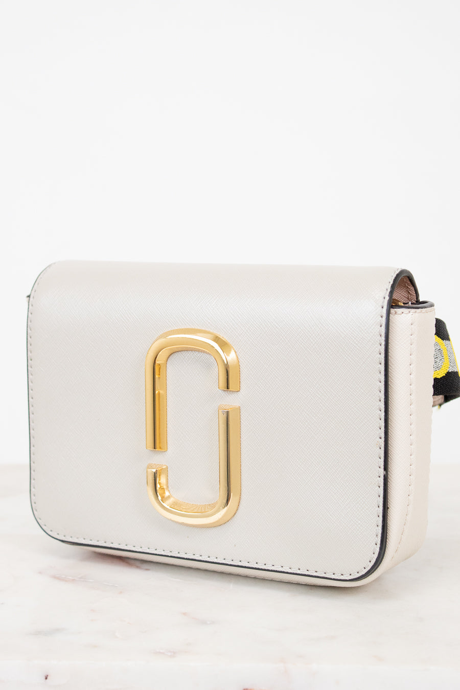 White handbag with gold logo on a white background
