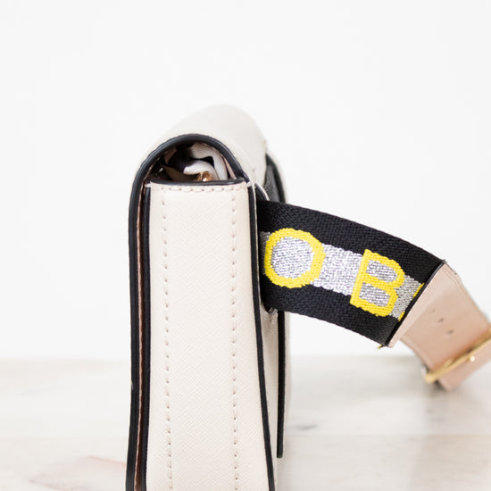 White purse with a black strap featuring yellow and gray accents on a white background