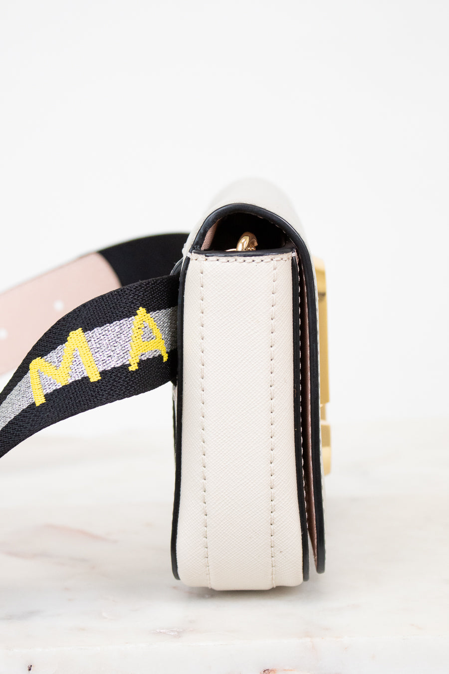 Close-up of a side of bag with 'Marc Jacobs' on the strap against a white background