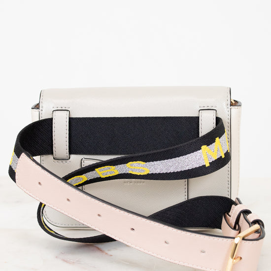 White handbag with a black strap featuring yellow text on a white background