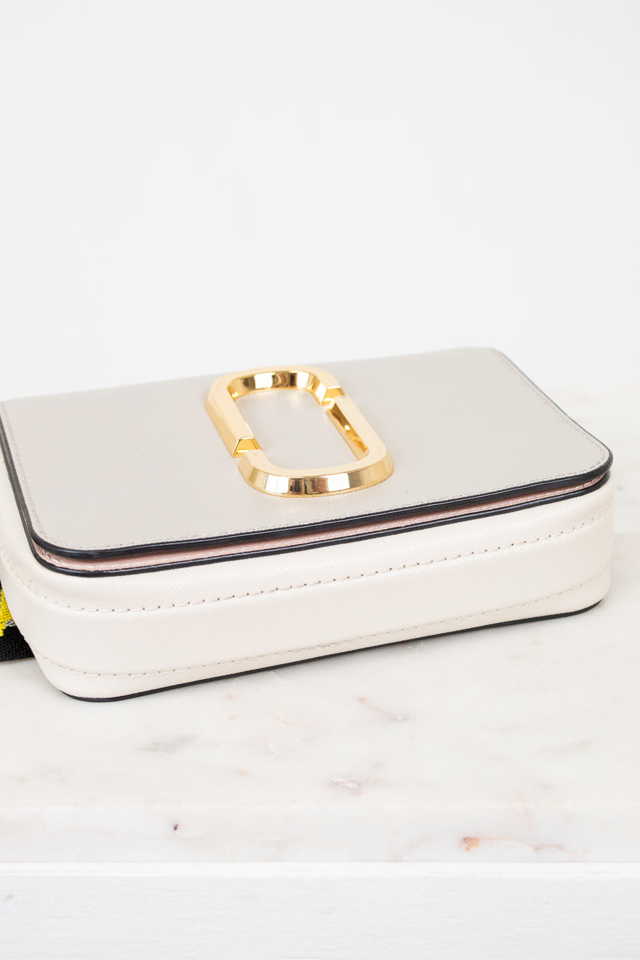 White handbag with gold clasp on a light background