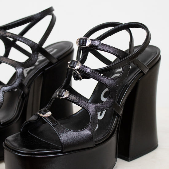 Black platform sandals with thin straps on a light background