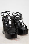 Black platform sandals with 'Marc' branding on a light background