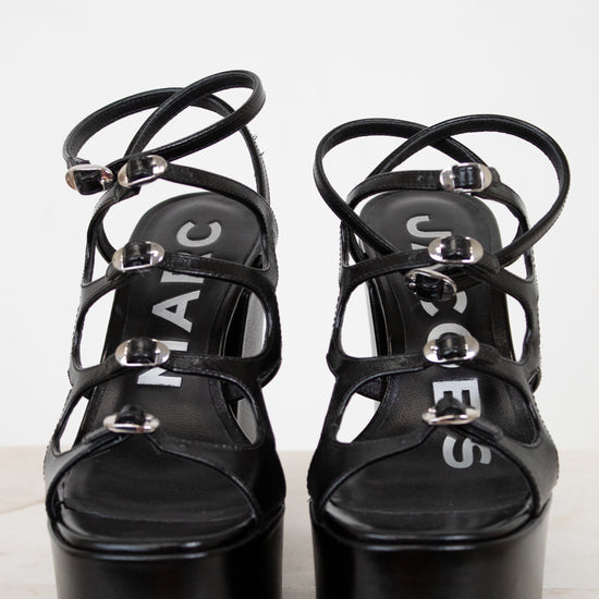 Black platform sandals with strappy design on a white background