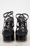 Black platform sandals with strappy design on a white background