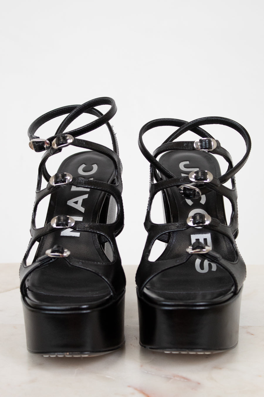 Black platform sandals with strappy design on a white background