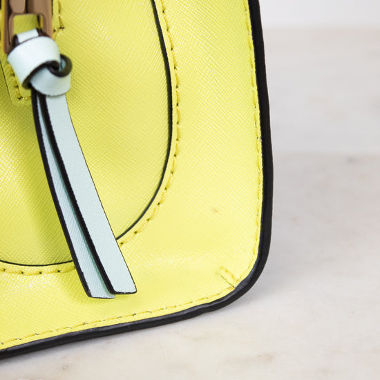 Close-up of a yellow handbag on a light marble background