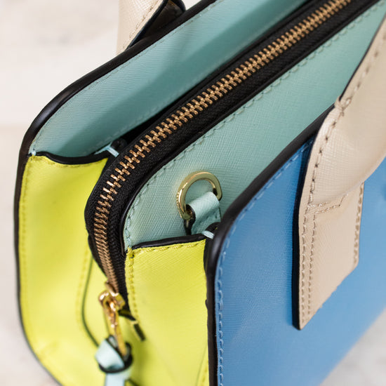 Colorful handbag with a gold zipper on a light background