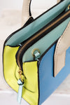 Colorful handbag with a gold zipper on a light background