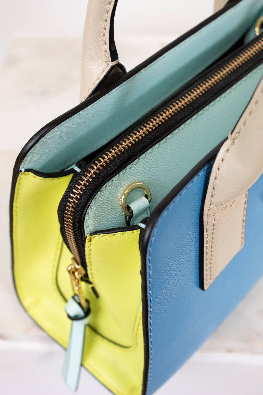 Colorful handbag with a gold zipper on a light background