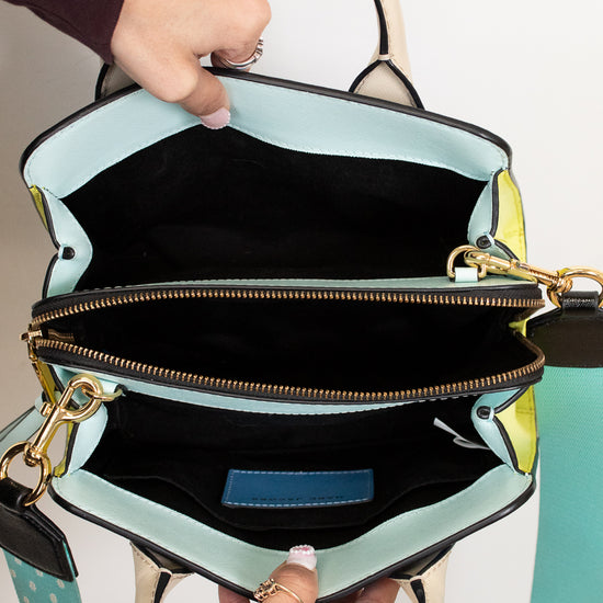 Handbag with a visible interior and strap, held by a person.