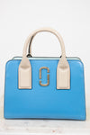 Blue handbag with beige handles and gold clasp on a white background