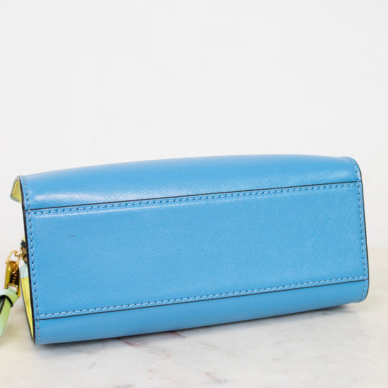 Blue bottom of purse with gold accents on a white marble surface
