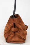 A brown suede bucket bag with a black leather strap and trim, shown against a plain white background.