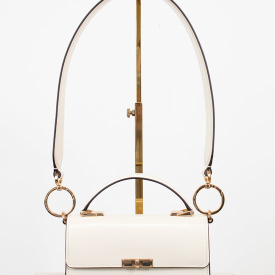 White handbag with gold accents on a white background
