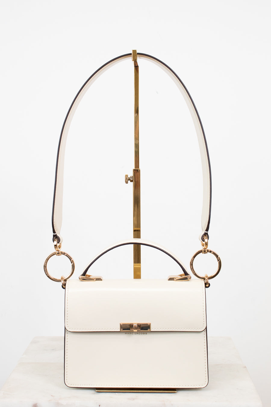 White handbag with gold accents on a white background