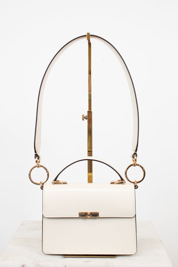 White handbag with gold accents on a white background